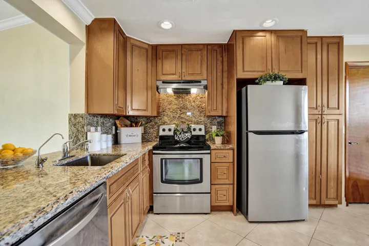 Updated kitchen with wood cabinets, stainless steal appliances and granite countertopsEat