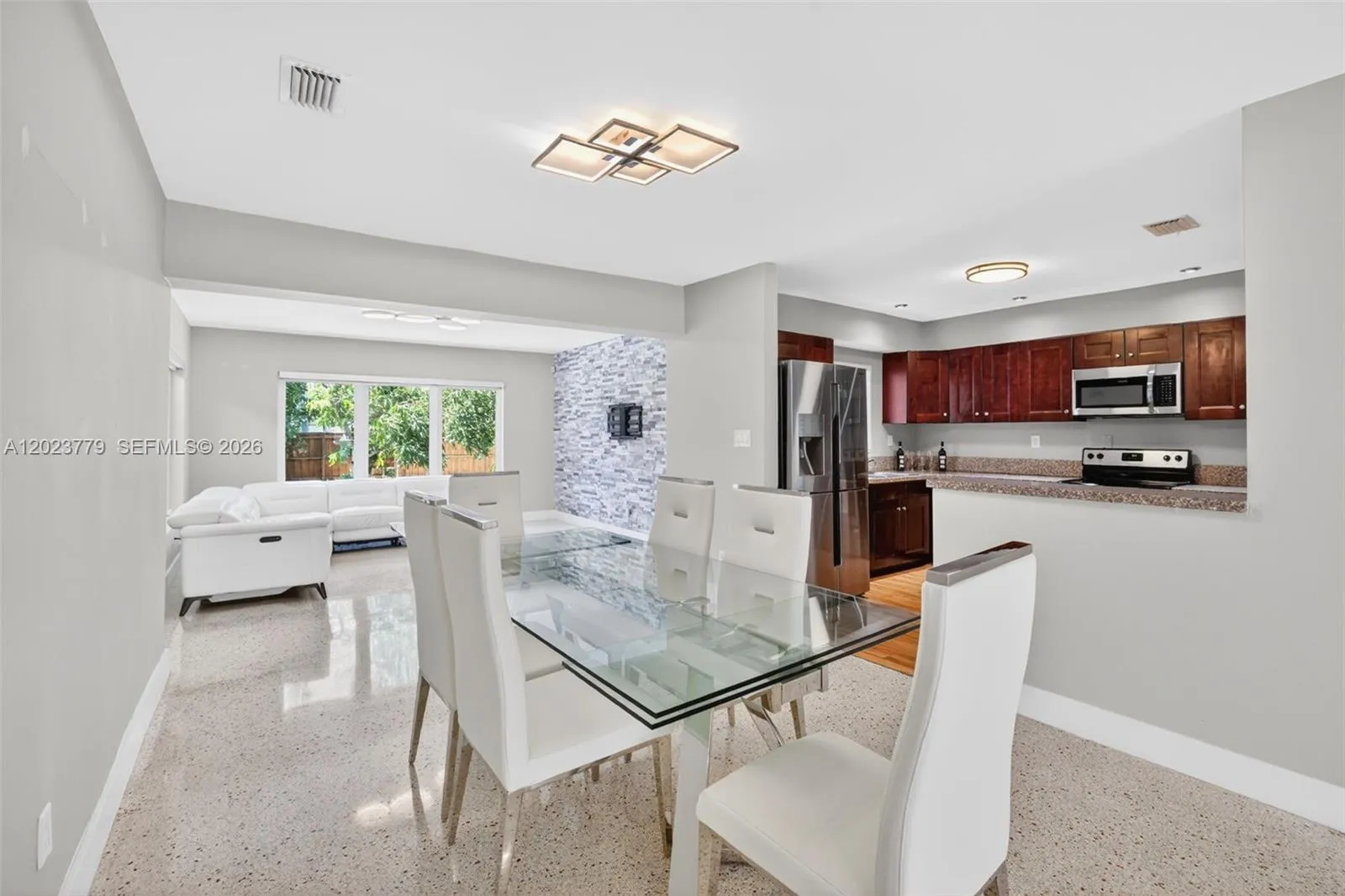 Dining area with flushmount fixture next to open concept kitchen