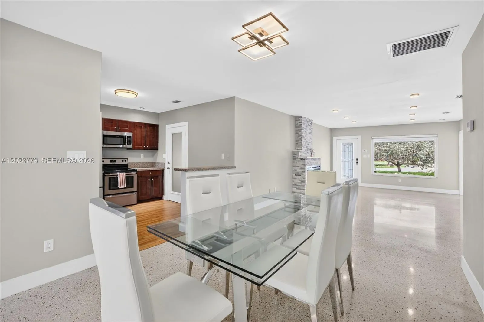 Dining area with flushmount fixture next to open concept kitchen