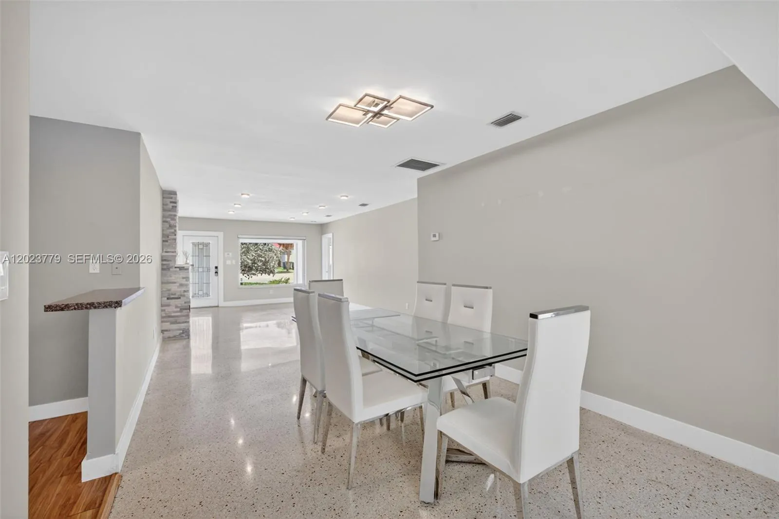 Dining area with flushmount fixture next to open concept kitchen