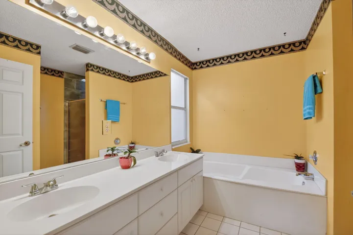 Primary bathroom boasts dual sinks, and a separate soaking tub and updated step in shower