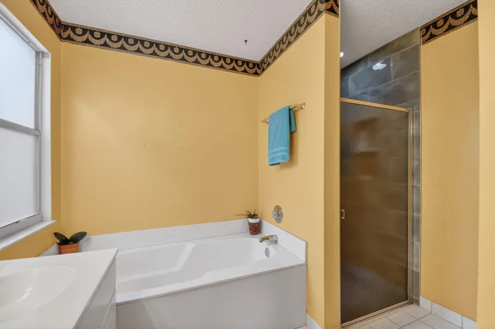 Primary bathroom boasts dual sinks, and a separate soaking tub and updated step in shower