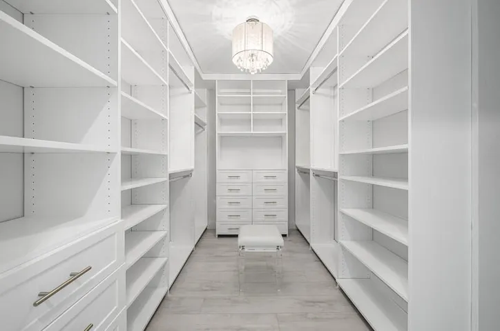 Primary walk-in closet and dressing area with lovely chandelier