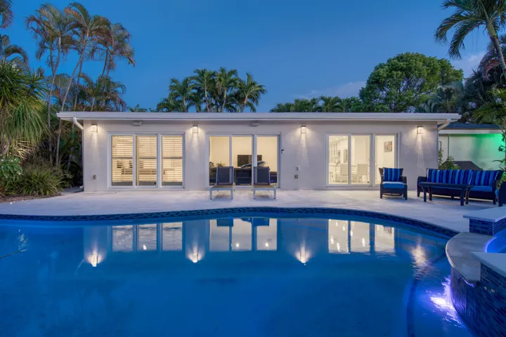 Evening view of the back of the house with the pool in the foreground
