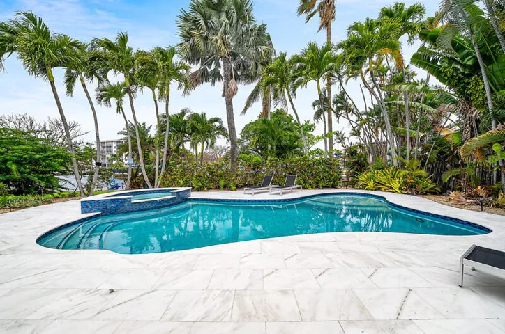 Large waterfront pool surrounded by a large patio