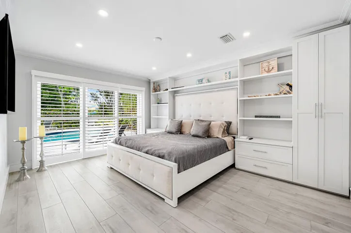Primary bedroom with a view of the pool and tons of built-ins