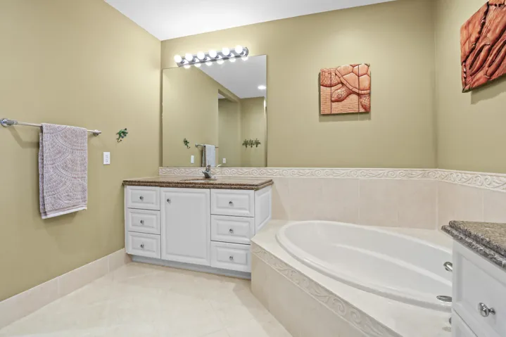 Dual sinks, large soaking tub, separate shower, and walk-in closets in primary bath