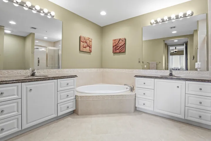 Dual sinks, large soaking tub, separate shower, and walk-in closets in primary bath