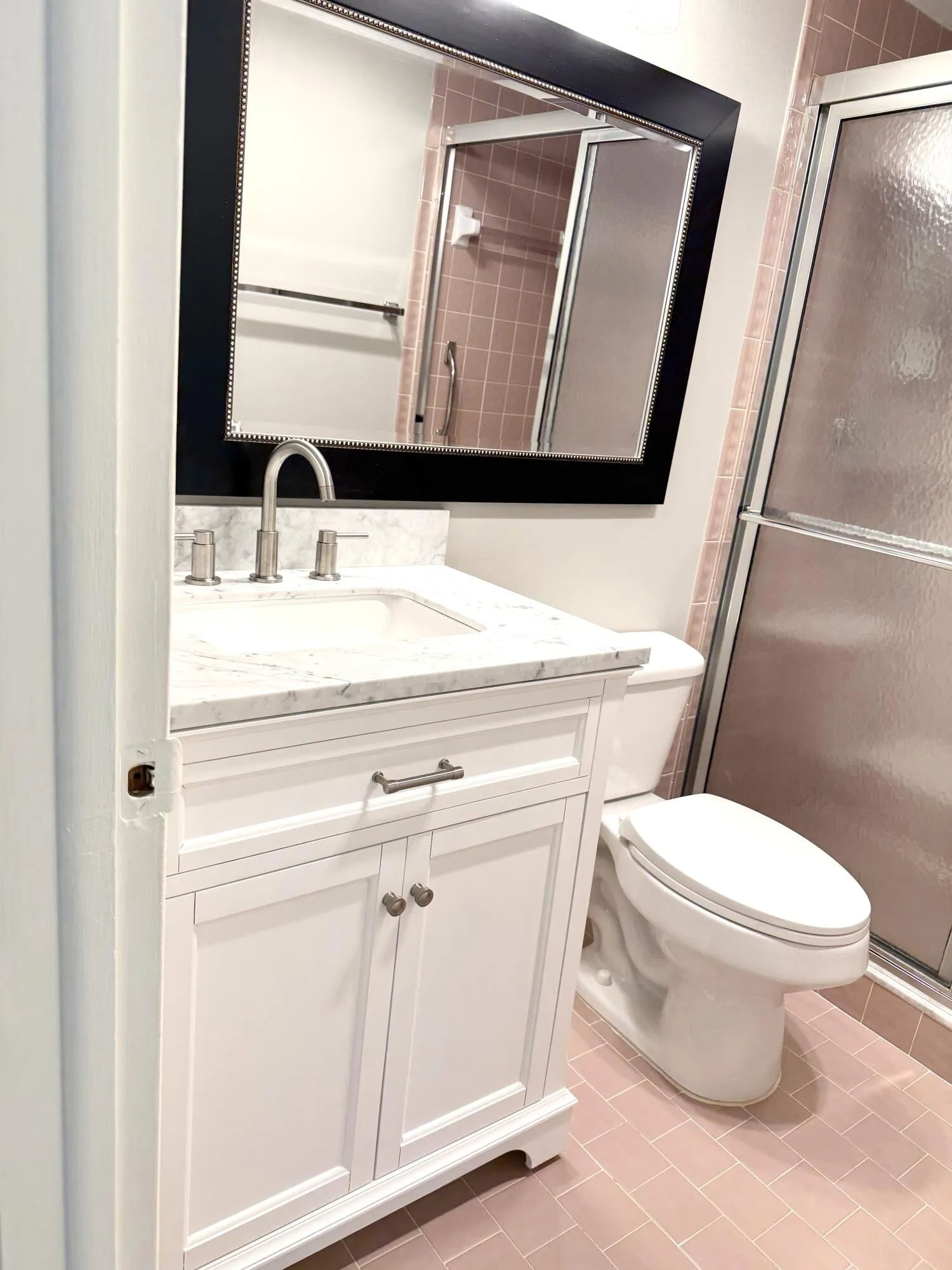 Bathroom with new vanity with carrara marble top and new faucet, also including brand new soft closed toilet seat.