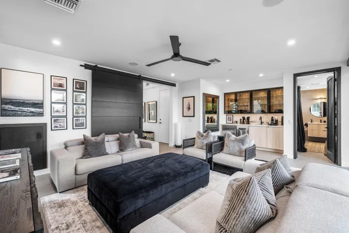 VIP Guest Suite on the ground floor with a wet bar, full bathroom, laundry room, and outdoor access to the pool and patio