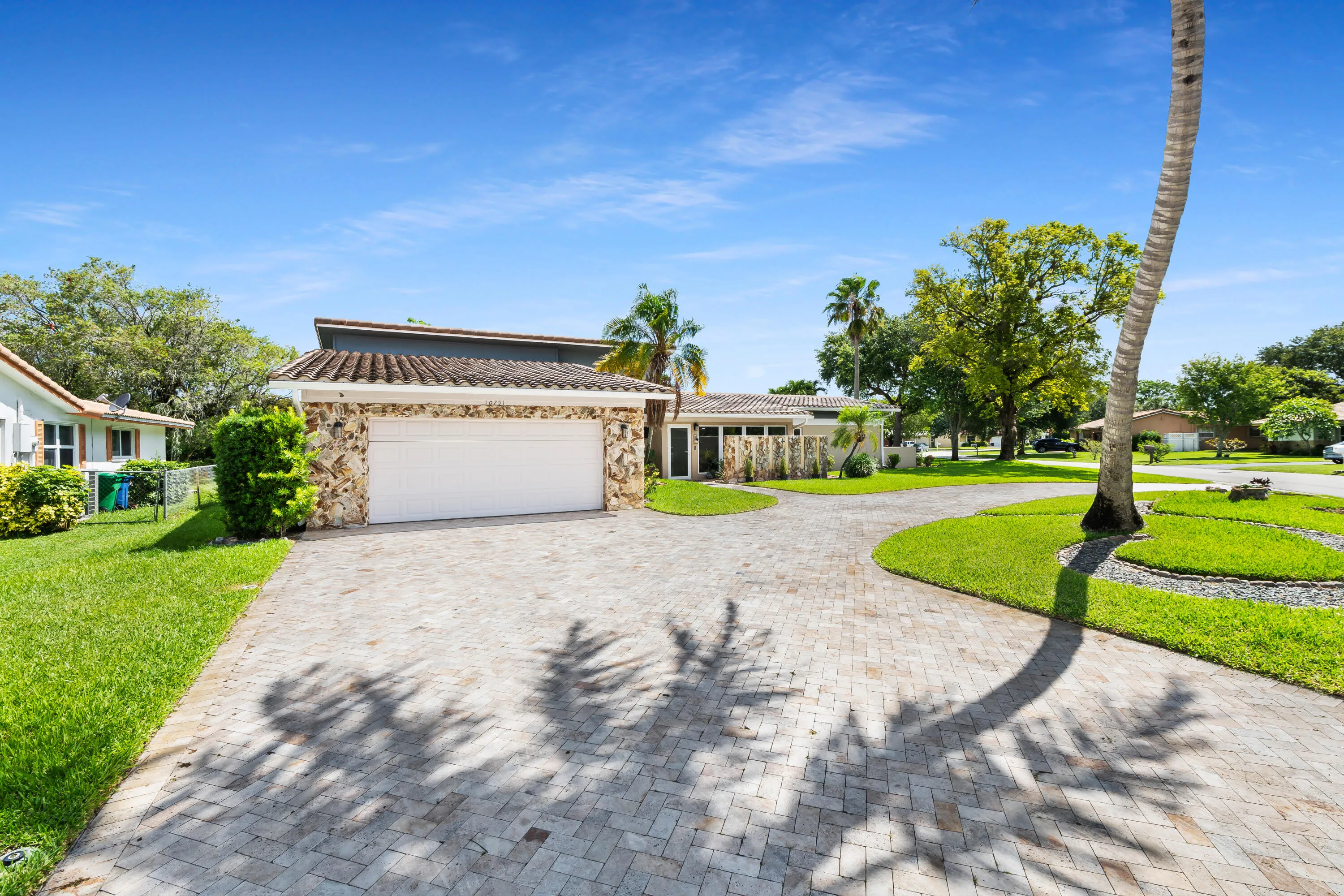 Front of house and lawn with huge half circle paver driveway