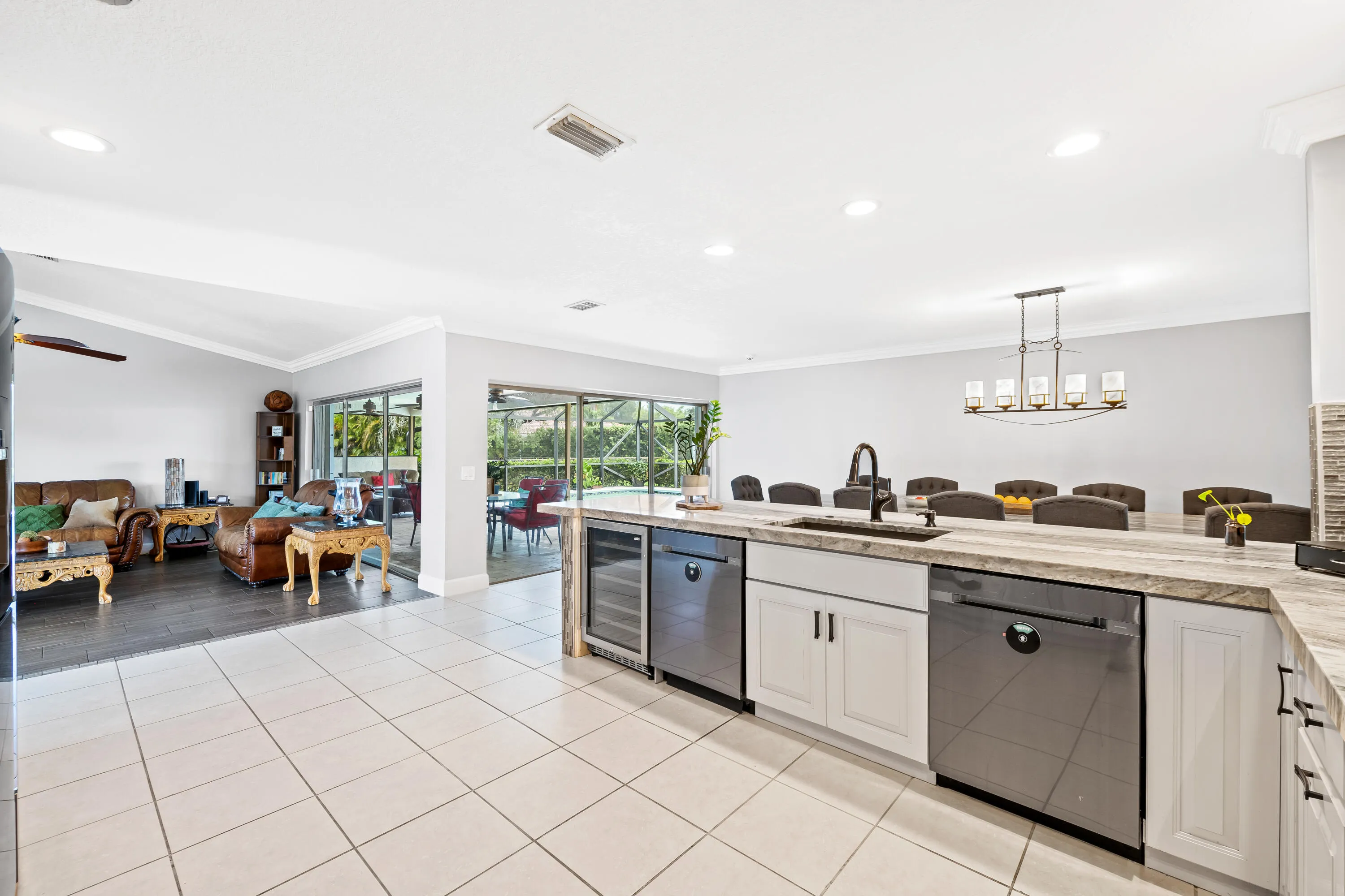 Kitchen with view to screened back patio with pavers, and saltwater pool and view of dining room and living room