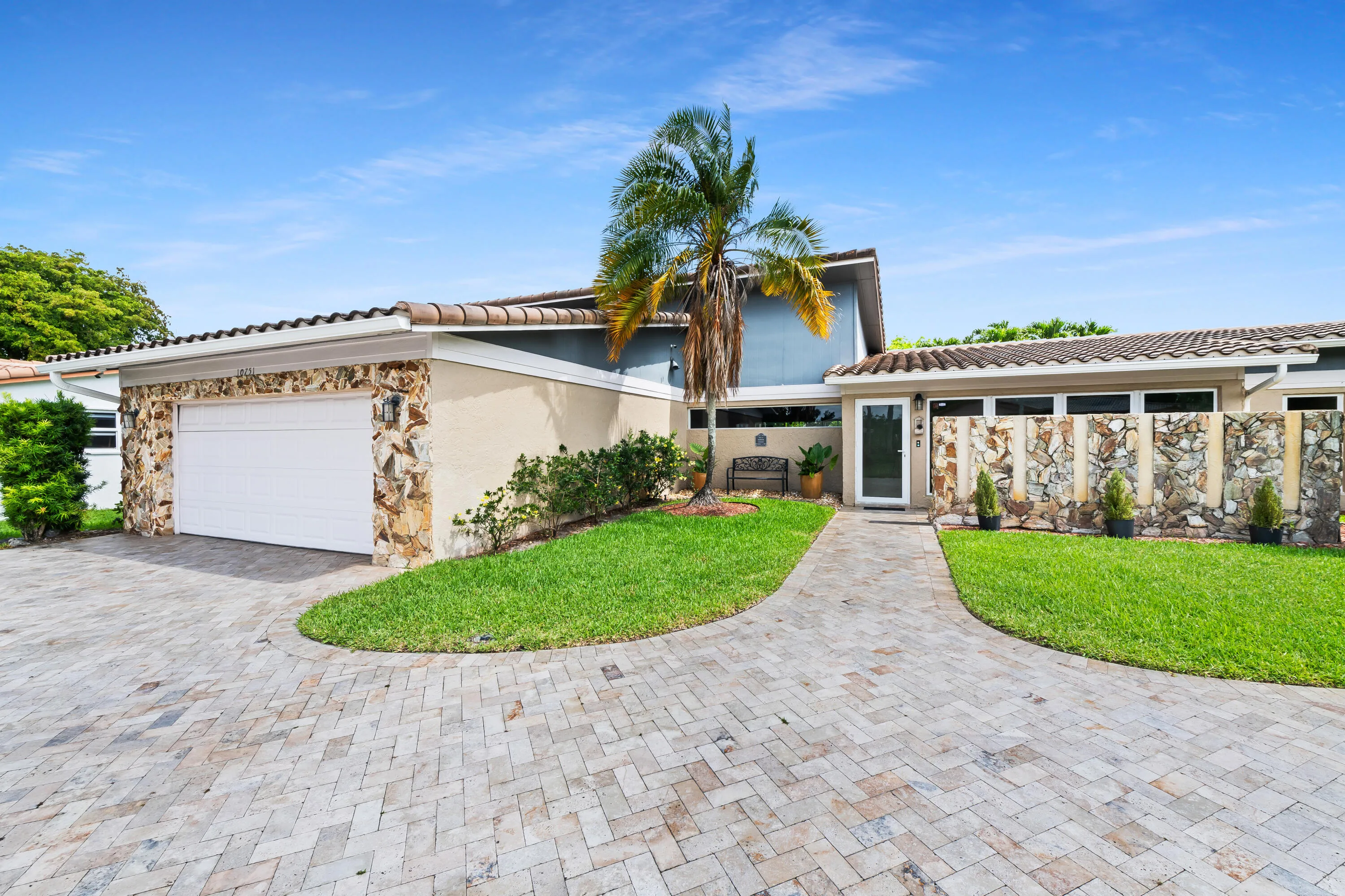 Front of house and lawn with huge paver driveway