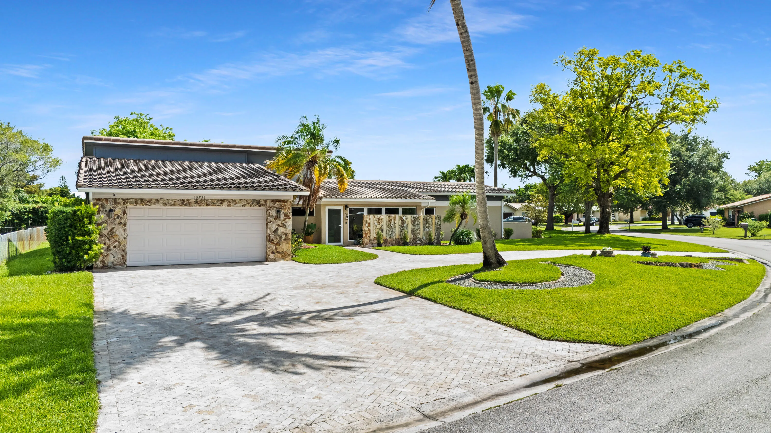 Front of house and lawn with huge half circle paver driveway