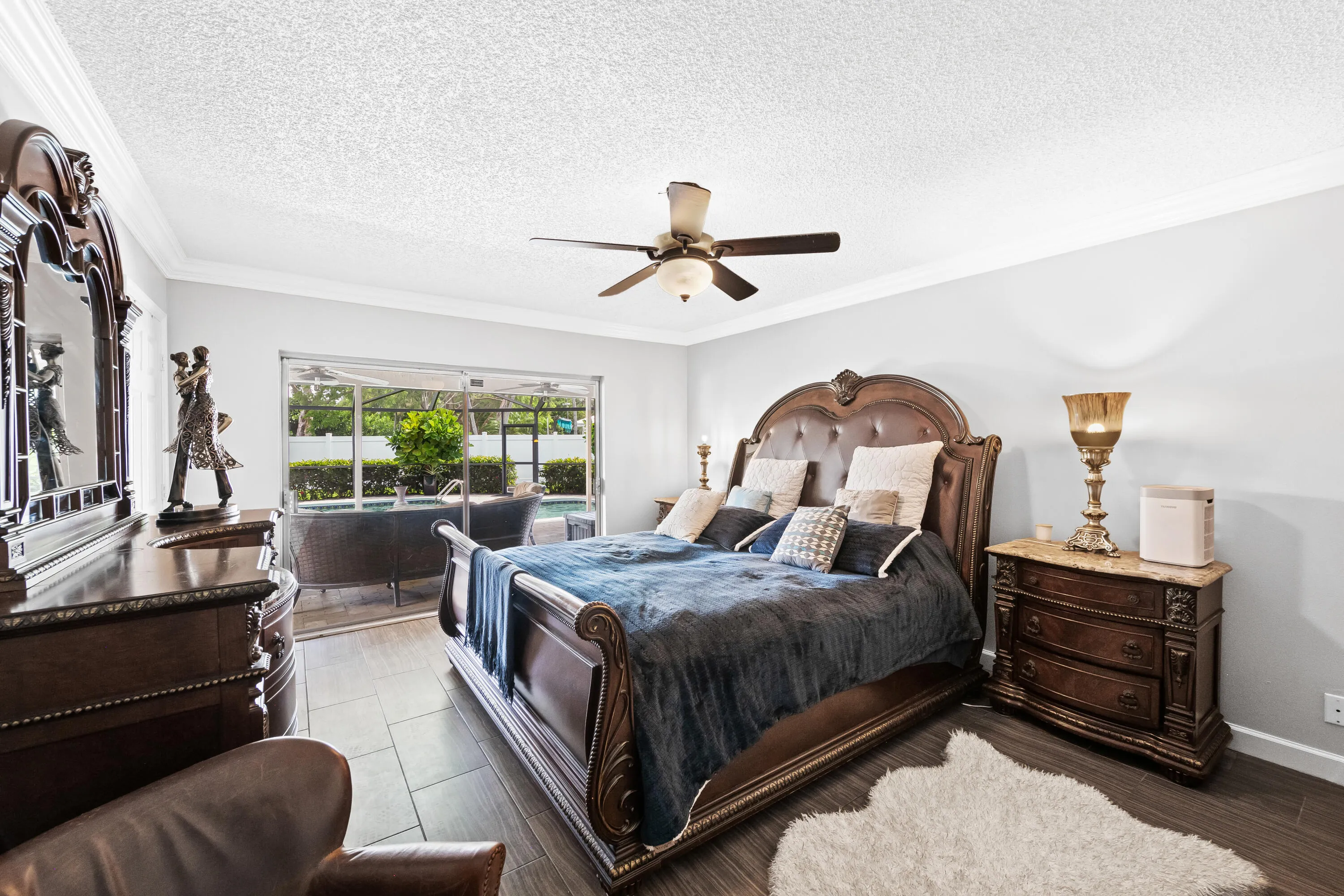 Primary Bedroom with view to back patio w/ pavers & saltwater pool