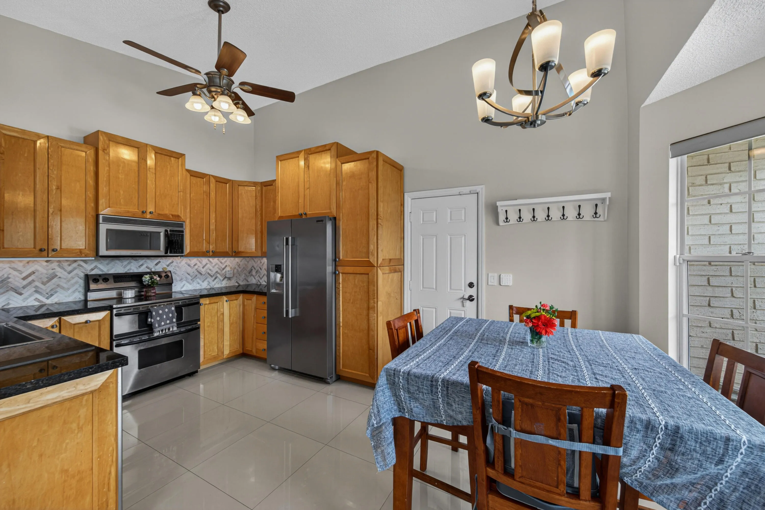 kitchen has lots of cabinetry for storage and a beautiful custom backsplash