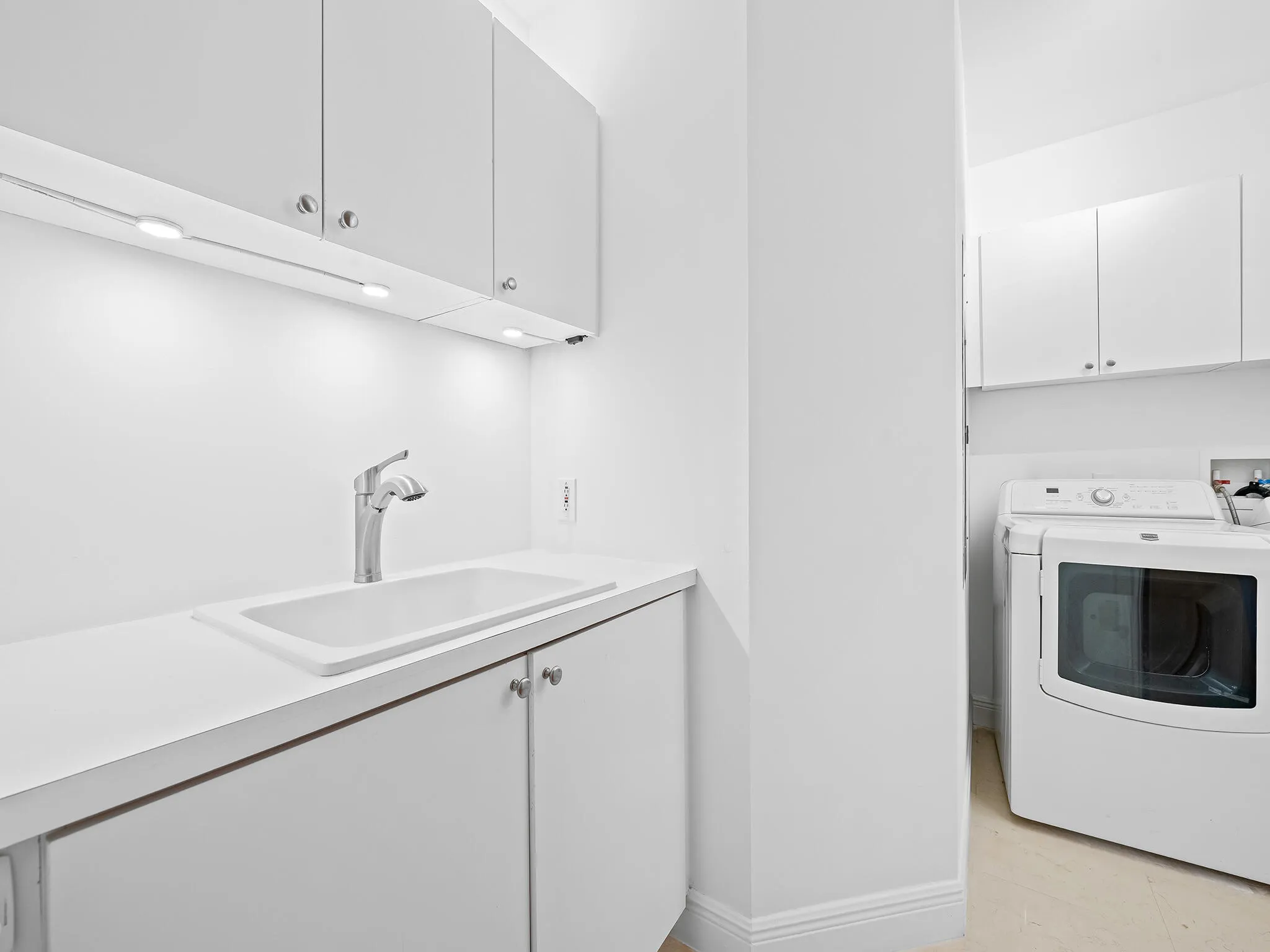 Laundry room featuring a utility sink and ample storage closets.