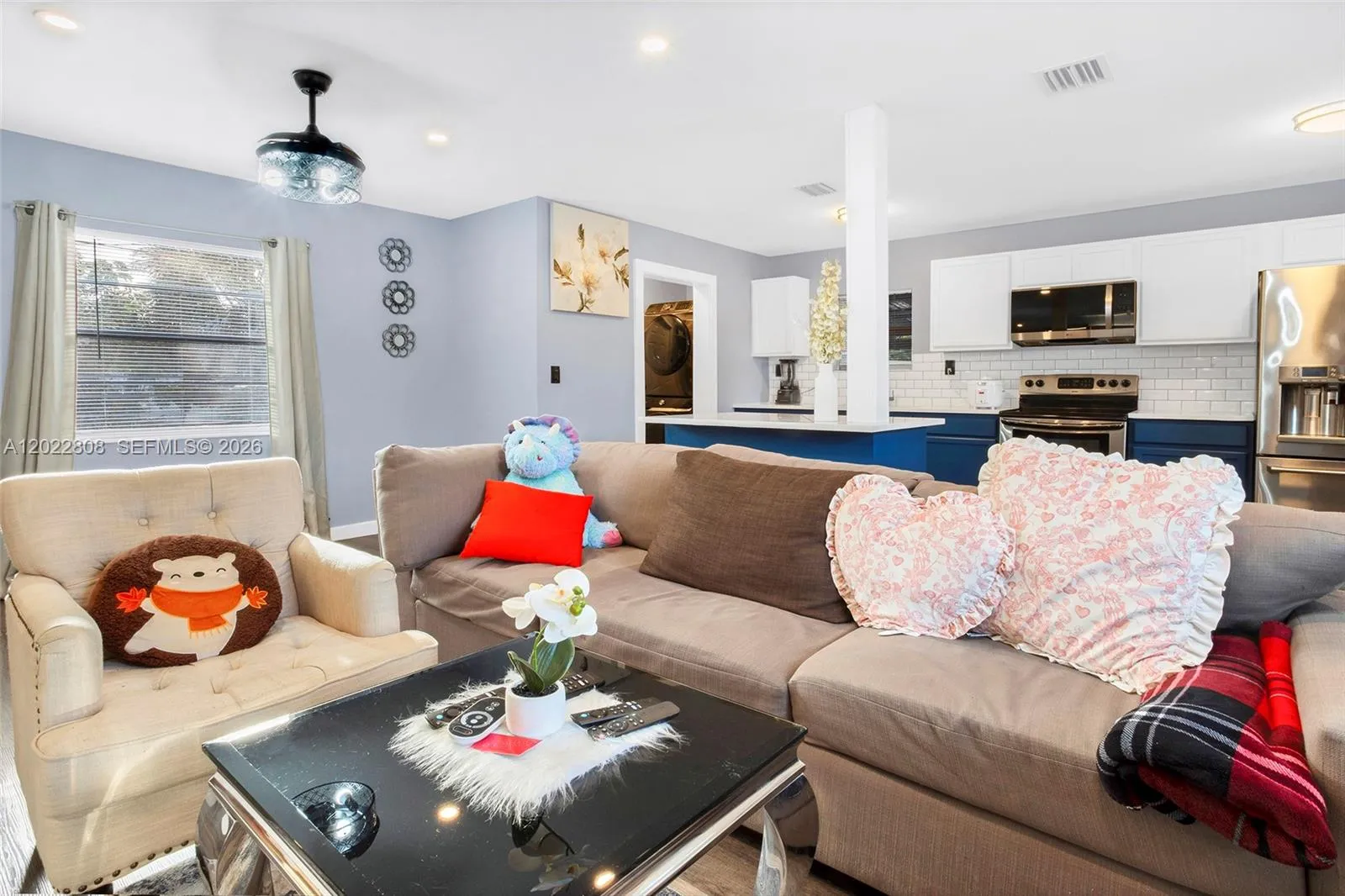 Bright open-concept family living area featuring modern flooring, recessed lighting, and a seamless flow to the kitchen—perfect for relaxing and entertaining.