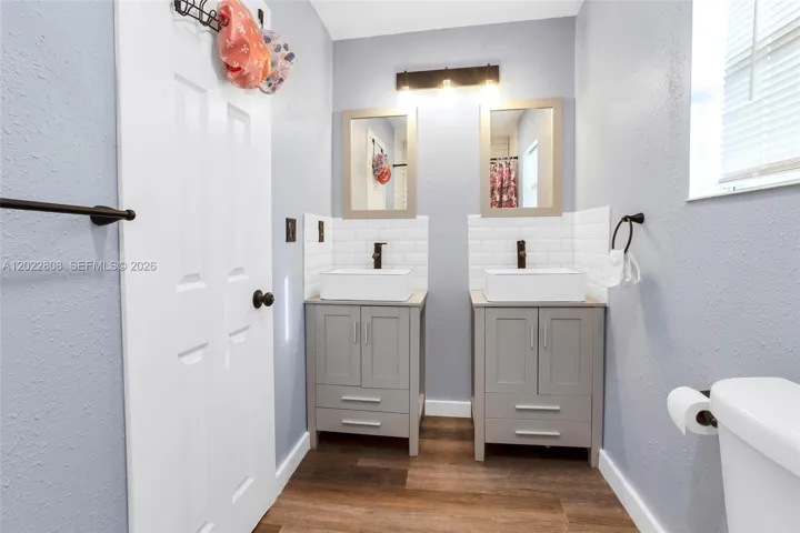 Featuring dual vanities, modern fixtures, and a beautifully tiled shower/tub combination.