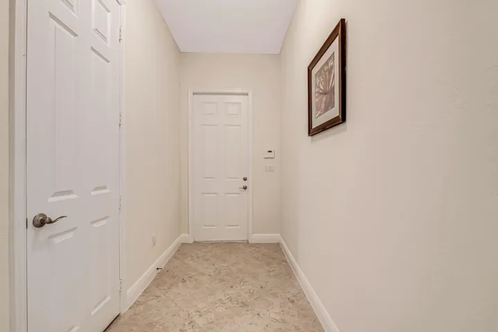 formal living room leading to hallway, primary bedroom, patio