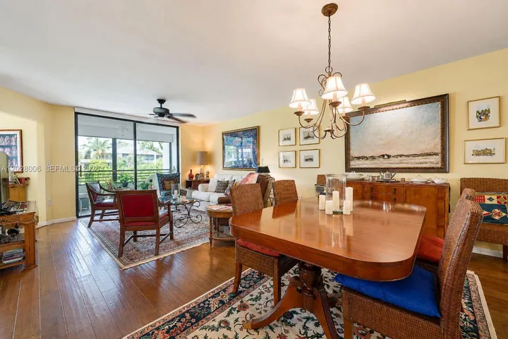 The spacious dining-living area features wide-plank wood-like floors and opens to the lanai with views from the 2nd floor over the landscaped gardens of the east courtyard