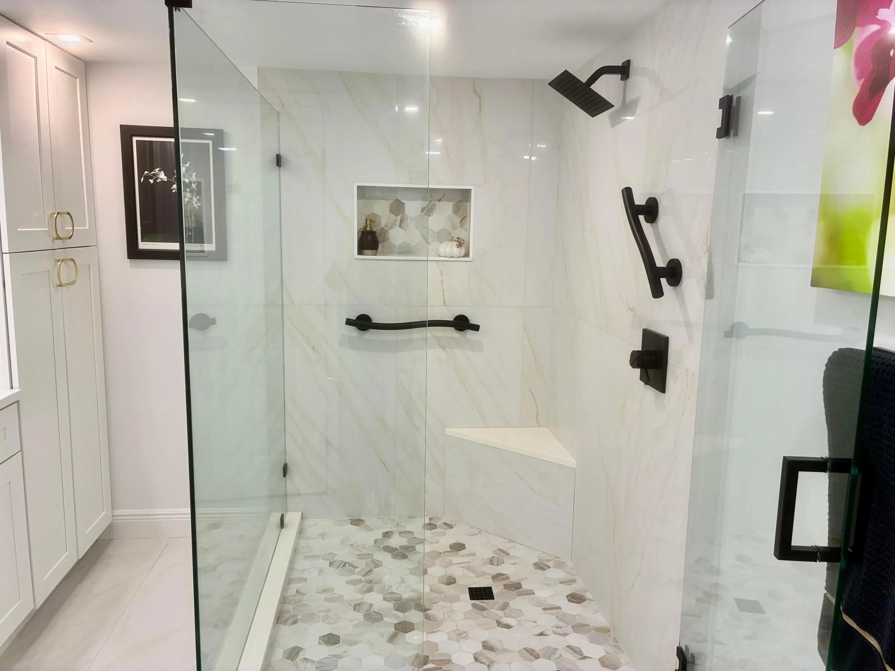 Frameless Shower With Decorative Tiles and Grab Bars
