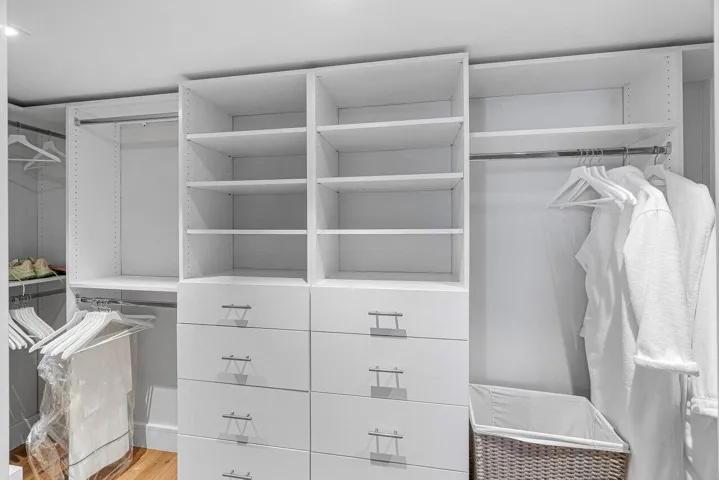 LARGE WALK IN PRIMARY CLOSET WITH CUSTOM CABINETS