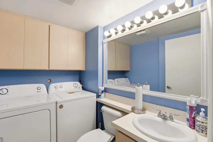 The laundry area is conveniently located just off the kitchen and tucked inside the half bath for added functionality.