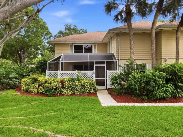 Relax and unwind on the screened patio overlooking a peaceful garden setting with lush tropical landscaping.