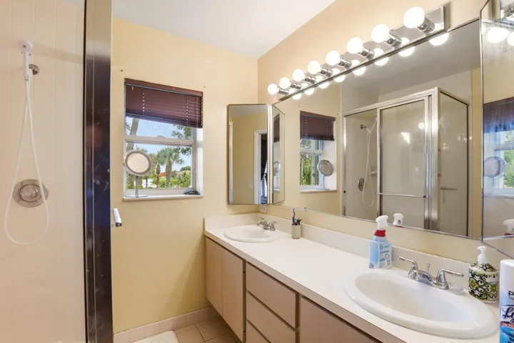The primary bathroom features dual sinks, providing plenty of space for your daily routine. A step-in shower adds convenience and easy accessibility.