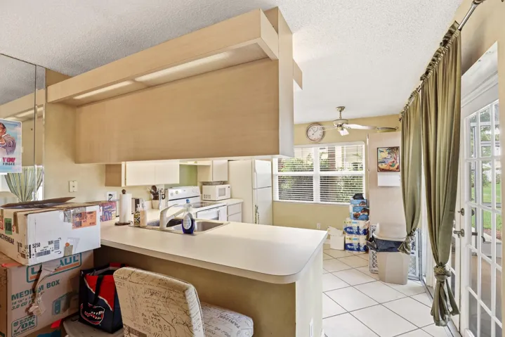 The breakfast bar provides casual seating, while French doors fill the kitchen with natural light and offer easy access to the screened patio.
