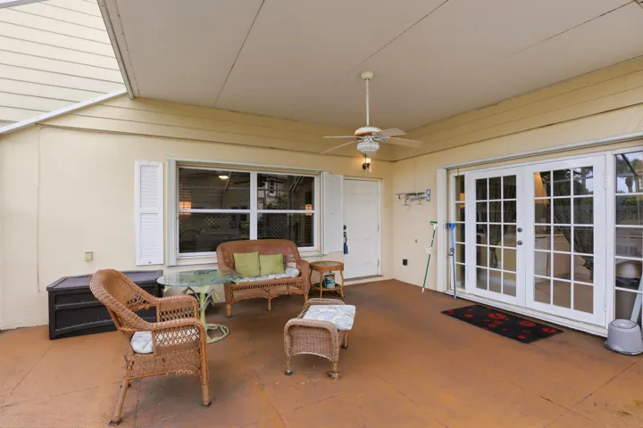 French doors, accordion shutters, and charming details create a welcoming transition between indoor and outdoor living.