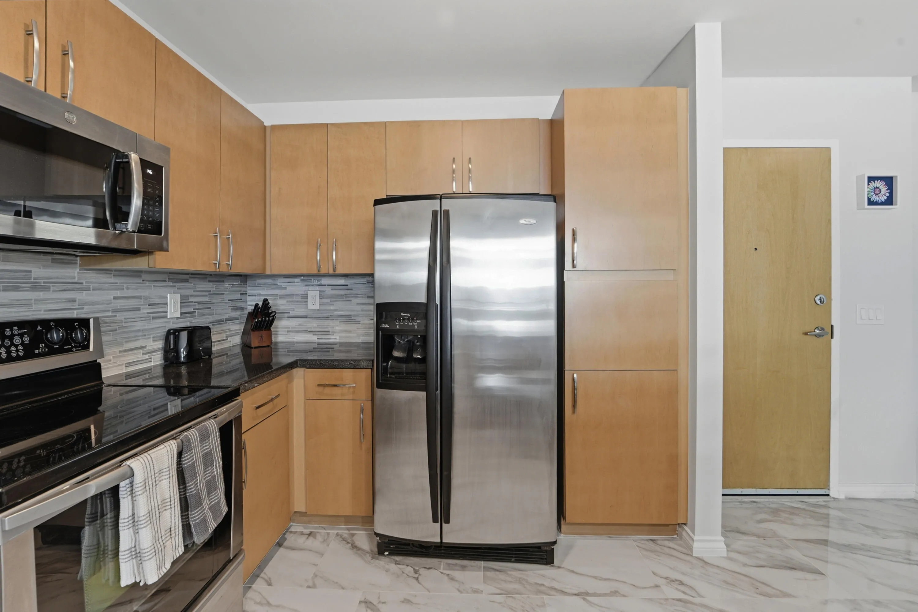 Open-concept kitchen with ample cabinetry, pantry, and island