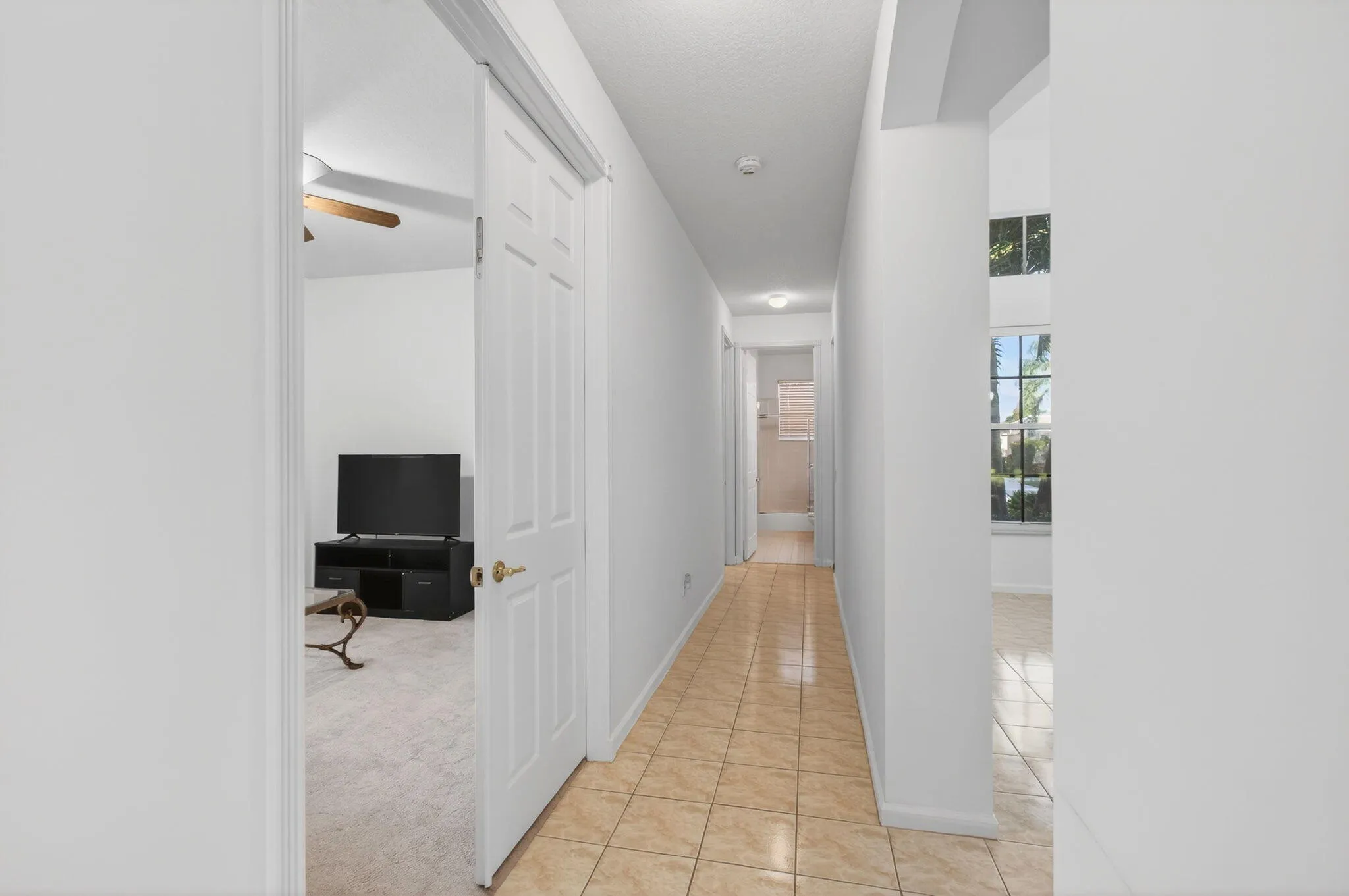 Hallway beyond dining room and kitchen leads to guest wing