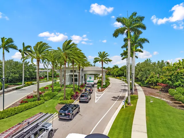 Grand gated entrance with 24-hour guard-gated security and lush tropical landscaping.