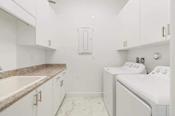 Spacious laundry room with built-in cabinetry and utility sink.