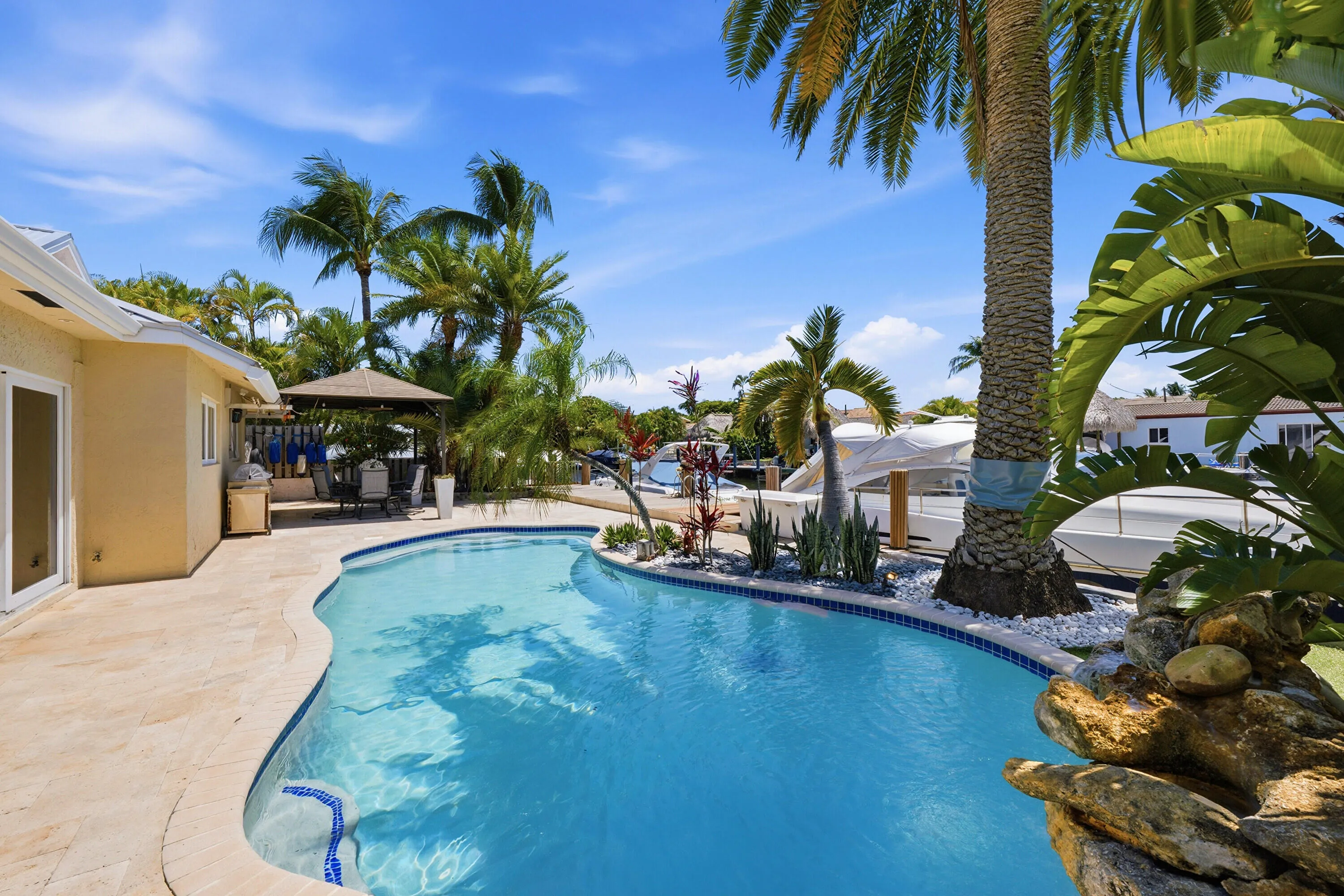 Imagine the momories You, Your Family & Friends will be making in the Tropical Waterfront Oasis, Lush Landscape, Pool with Rock Waterfall, Covered Patio, Dock and Travertine Pavers.