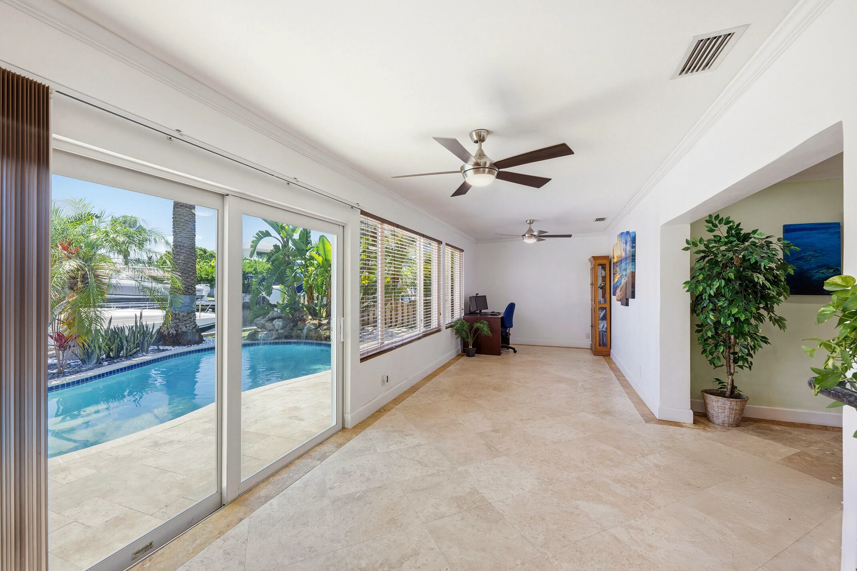 Your Florida Room has Front Seat to Your Specatular Waterfront Home with a Freeform Pool with Rock Waterfall, Dock, Covered Patio and Travertine Tile Pavers.