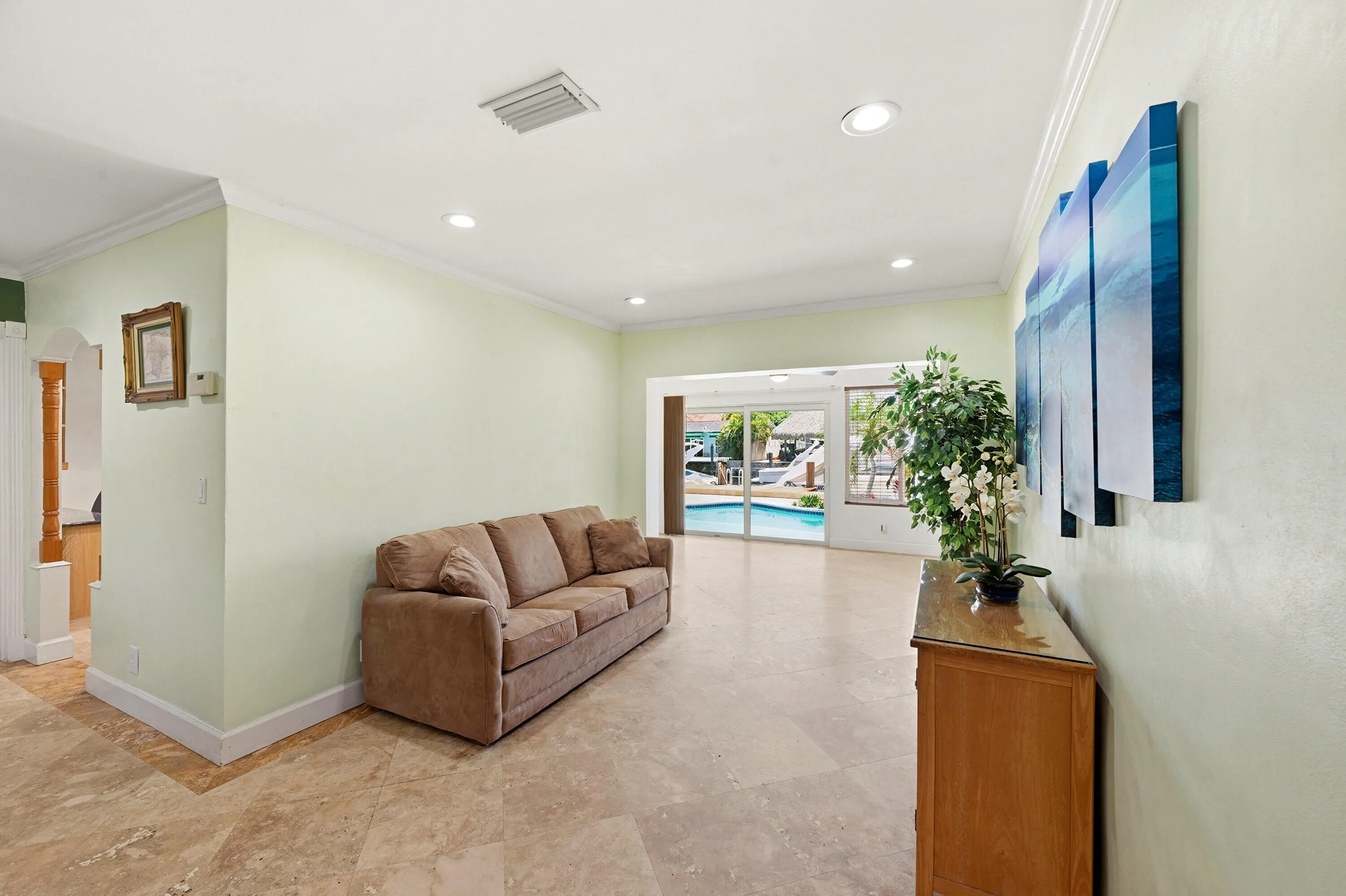 WOW! Your Living Room Views are Awesome! Living Room Extends towards the Backyard, Pool Dock Areas. 18" Travertine Tile Floors, Crown Modling and Impact Windows & Doors Throughout.