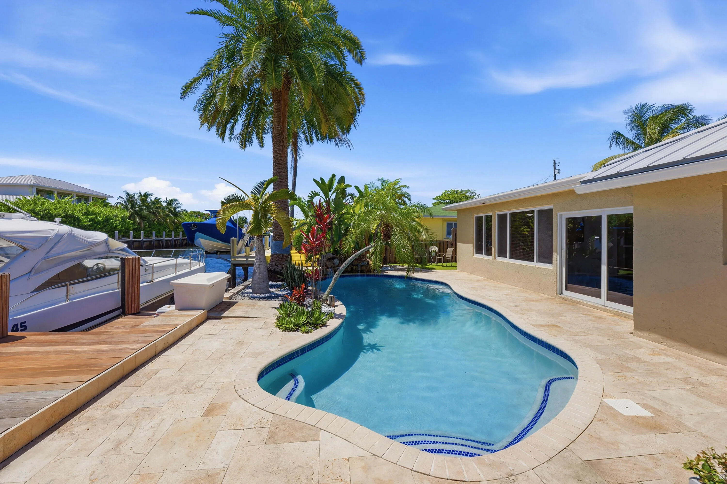 Beautiful Landscape Surrounds Your Waterfront Freeform Pool with Rock Waterfall adds to the Serene Waterfront Lifestyle.