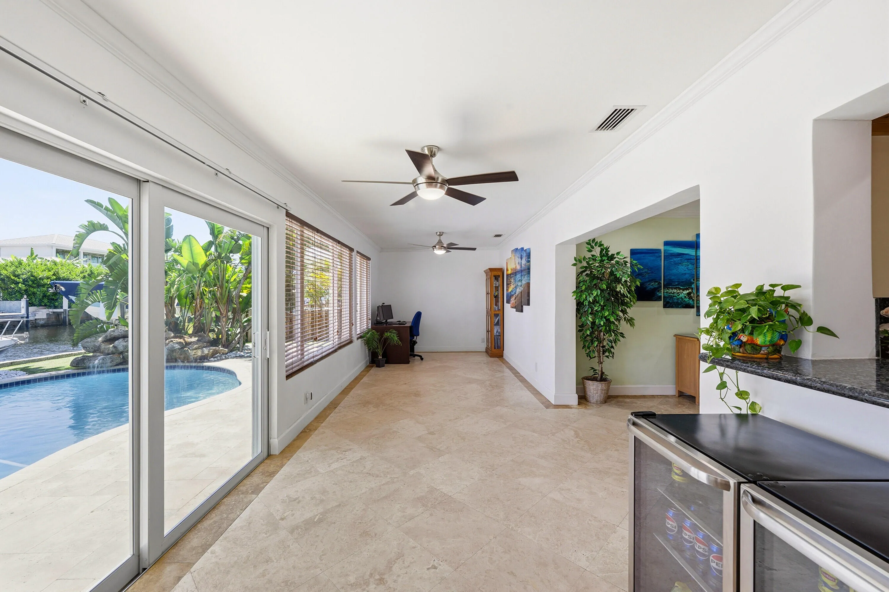 Your Florida Room has Front Seat to Your Specatular Waterfront Home with a Freeform Pool with Rock Waterfall, Dock, Covered Patio and Travertine Tile Pavers.