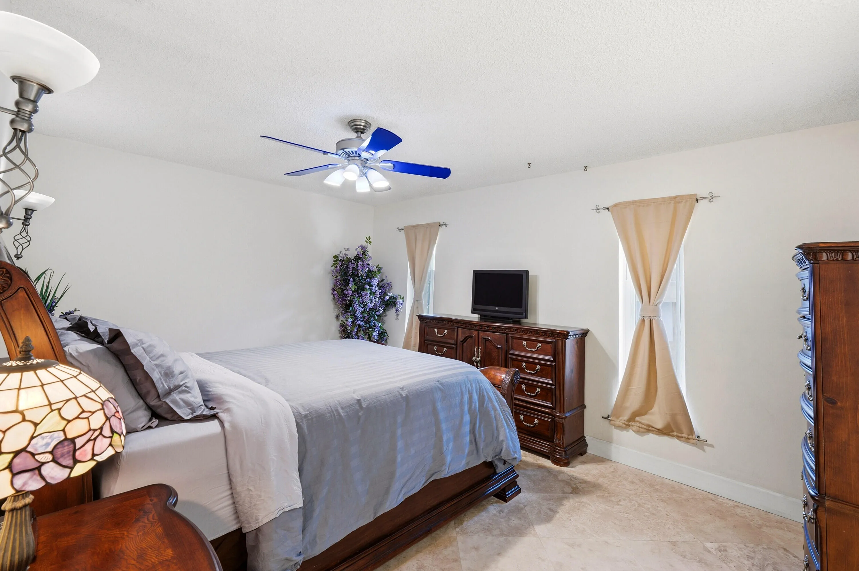 Primary Bedroom is off the Living Room and Includes an En-Suite Bathroom and Big Walk-In Closet Both with Frosted Glass Doors and 18" Travertine Tile Floors like the rest of the Home.