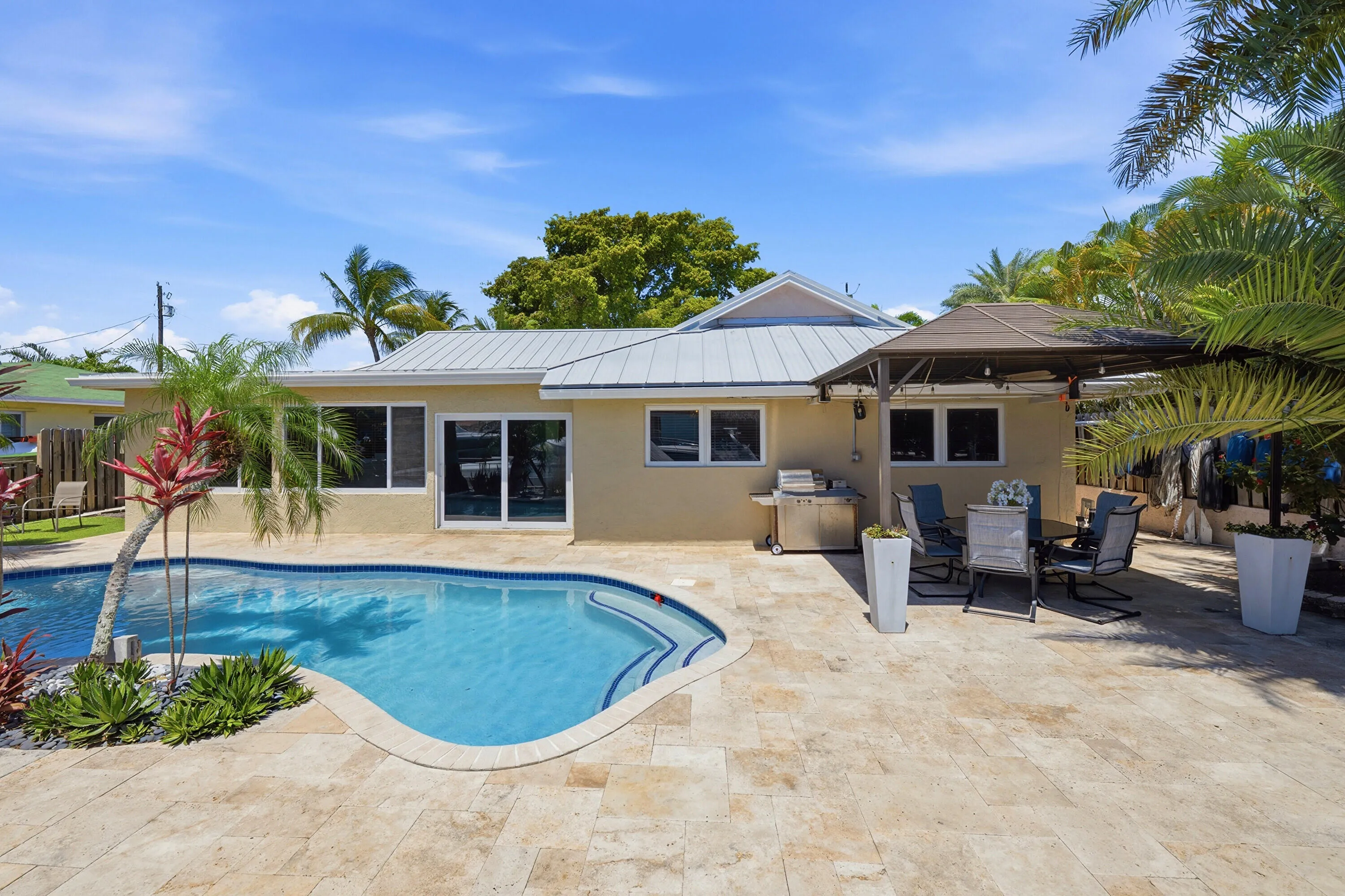 Freeform Pool with Rock Waterfall, Covered Patio Space for Fail Safe Outdoor Enteraining, 40' Dock, 70' Seawall, Aluminum Roof & Travertine Pavers 2024, Exterior Painted 2025.