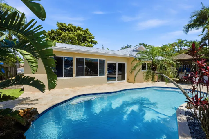 Beautiful Landscape Surrounds Your Waterfront Freeform Pool with Rock Waterfall adds to the Serene Waterfront Lifestyle.