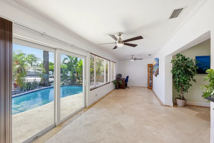 Your Florida Room has Front Seat to Your Specatular Waterfront Home with a Freeform Pool with Rock Waterfall, Dock, Covered Patio and Travertine Tile Pavers.