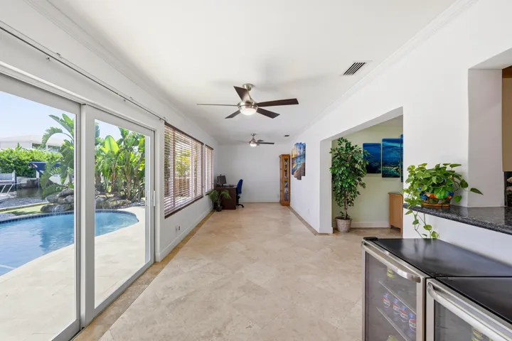 Your Florida Room has Front Seat to Your Specatular Waterfront Home with a Freeform Pool with Rock Waterfall, Dock, Covered Patio and Travertine Tile Pavers.
