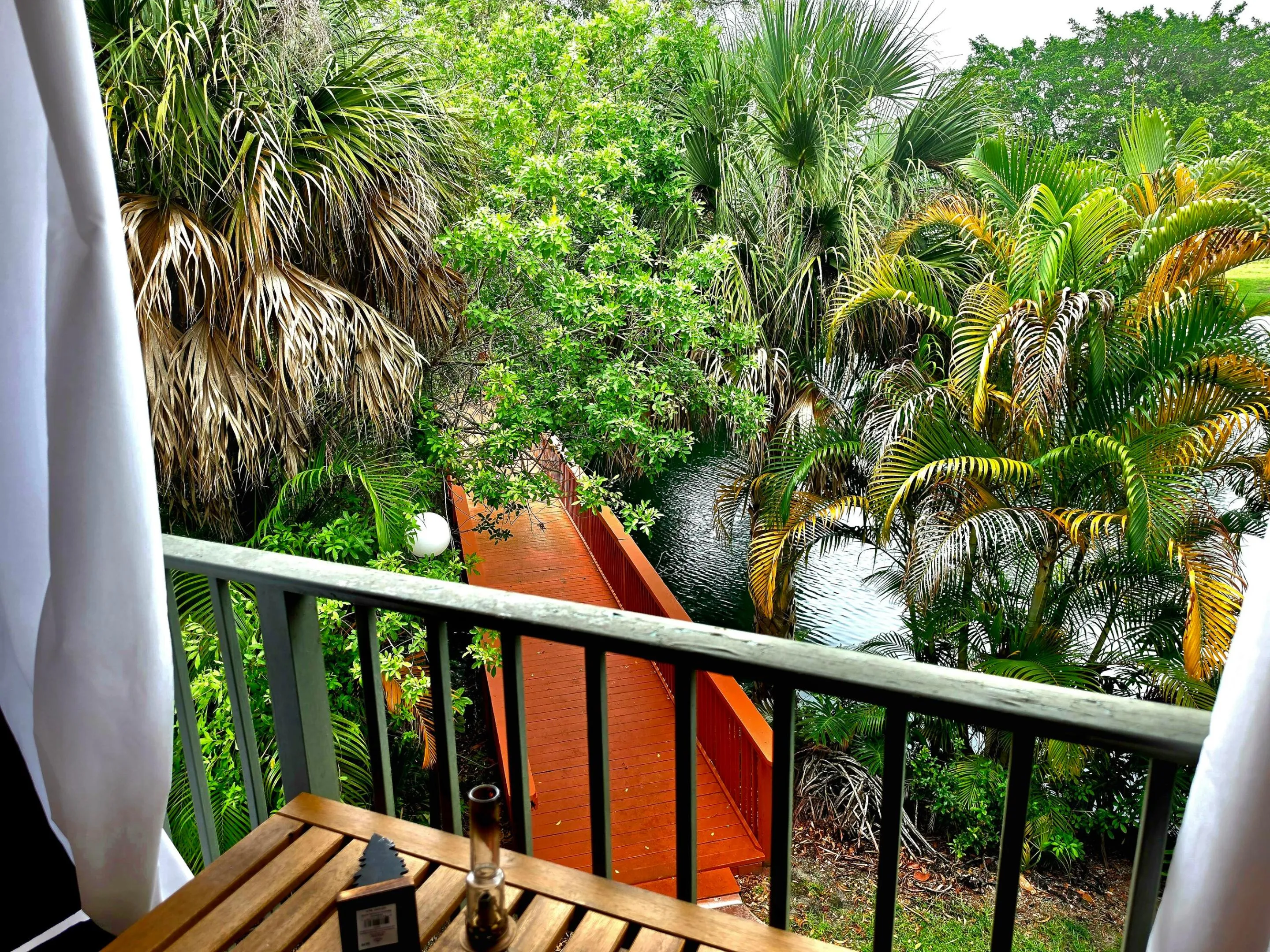 A PICTURESQUE WOODEN BRIDGE CROSSING THE LAGOON ADDS TO THE AMBIANCE
