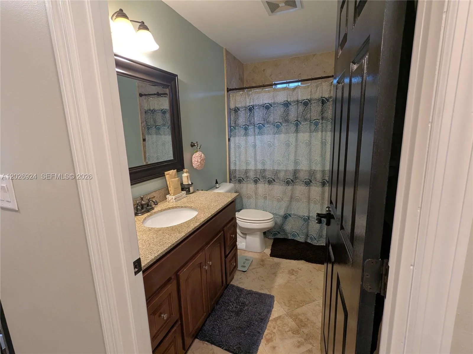 Second full bathroom featuring a granite-top vanity, modern lighting, and a clean tub/shower combo, offering a practical and well-maintained space for daily use.