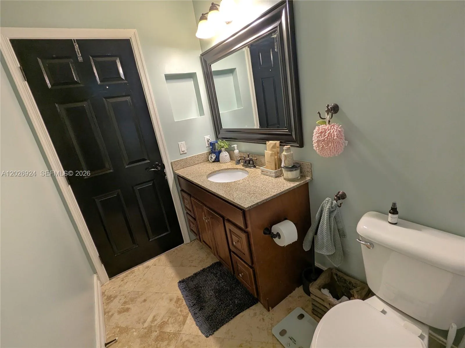 Second bathroom featuring a granite-top vanity, updated lighting, and a clean, well-maintained layout that provides comfort and functionality for daily use.