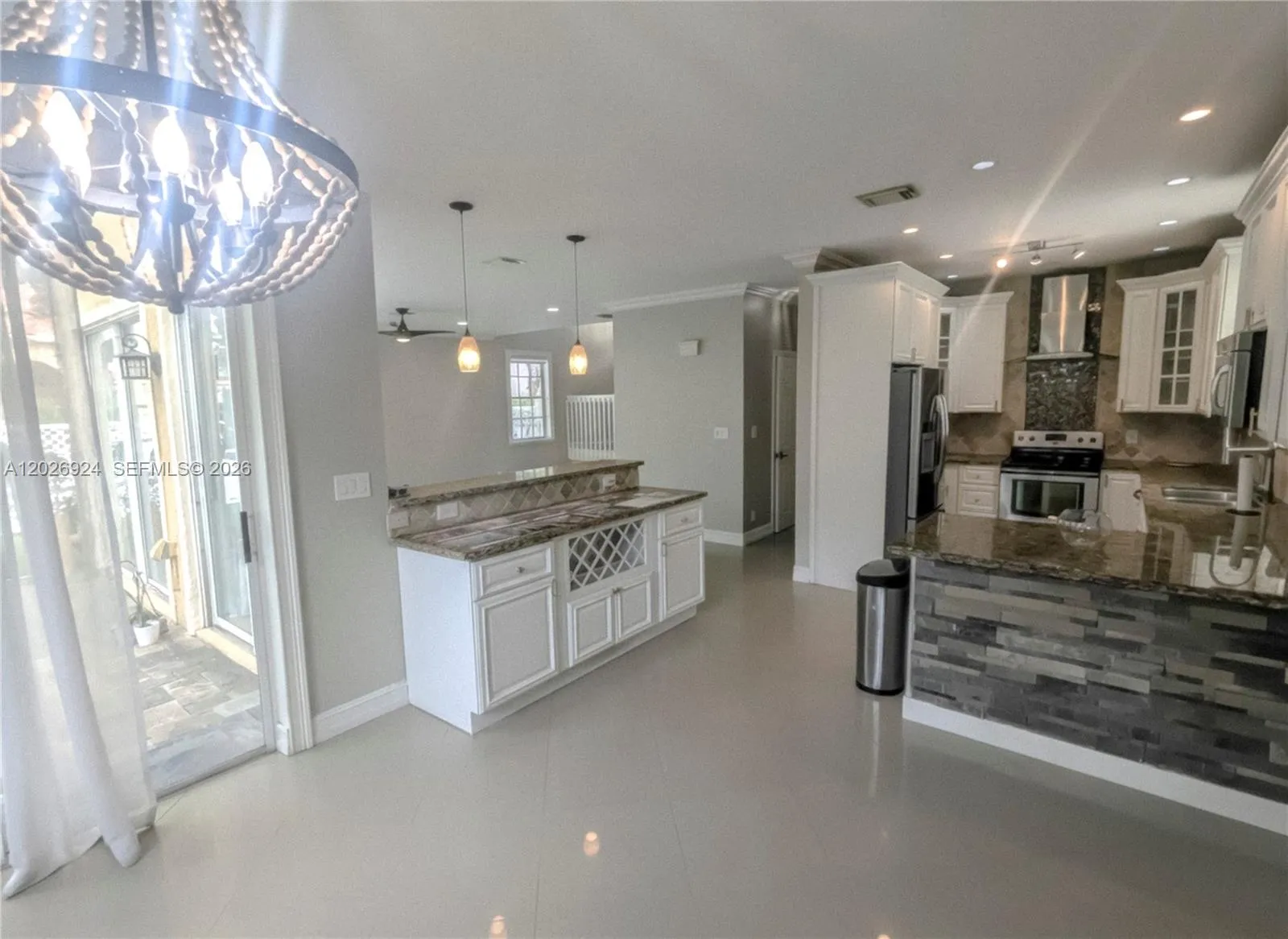 View from the dining area, where natural light flows seamlessly toward the screened patio, the counter bar, and the kitchen counter, while connecting effortlessly with the living room, guest bathroom, garage, and kitchen — a central hub perfect for your style and functionality